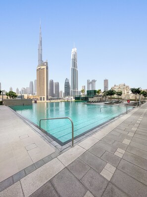 A swimming pool with a city skyline in the background.