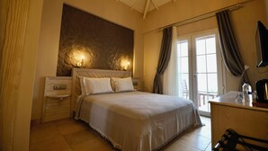 A bedroom with a large bed, bedside tables, a desk, and a view through the door.