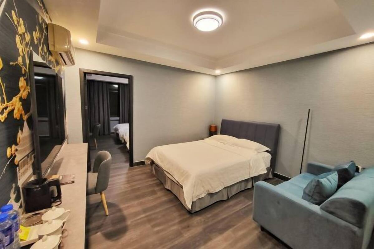 Une chambre d’hôtel moderne, dotée d’un grand lit, d’un bureau, d’une chaise et d’un canapé.