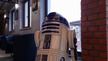 A R2-D2 droid model in a lobby area with seating and a large window.