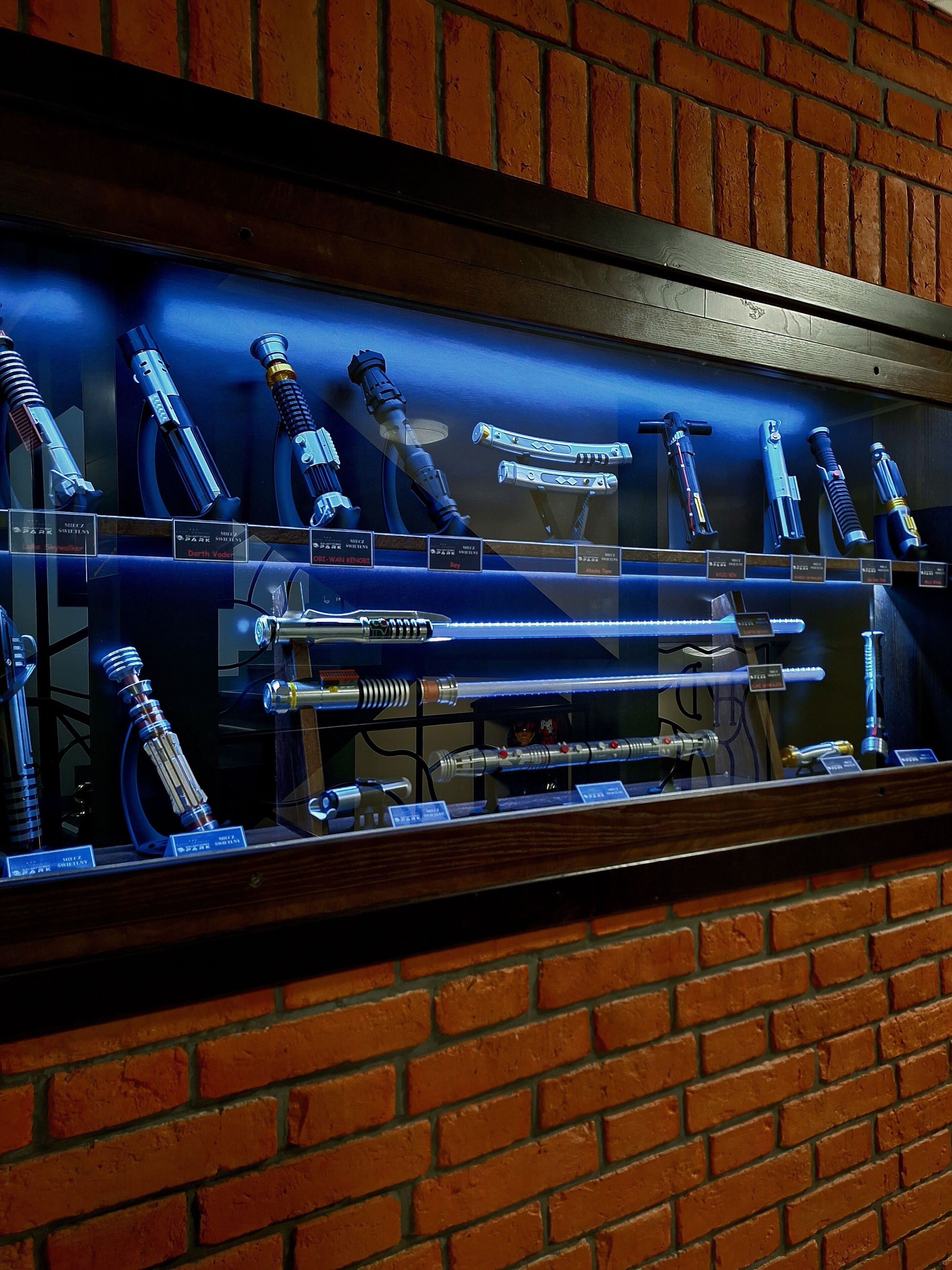 A display of various mechanical devices in a glass case, set against a brick wall.