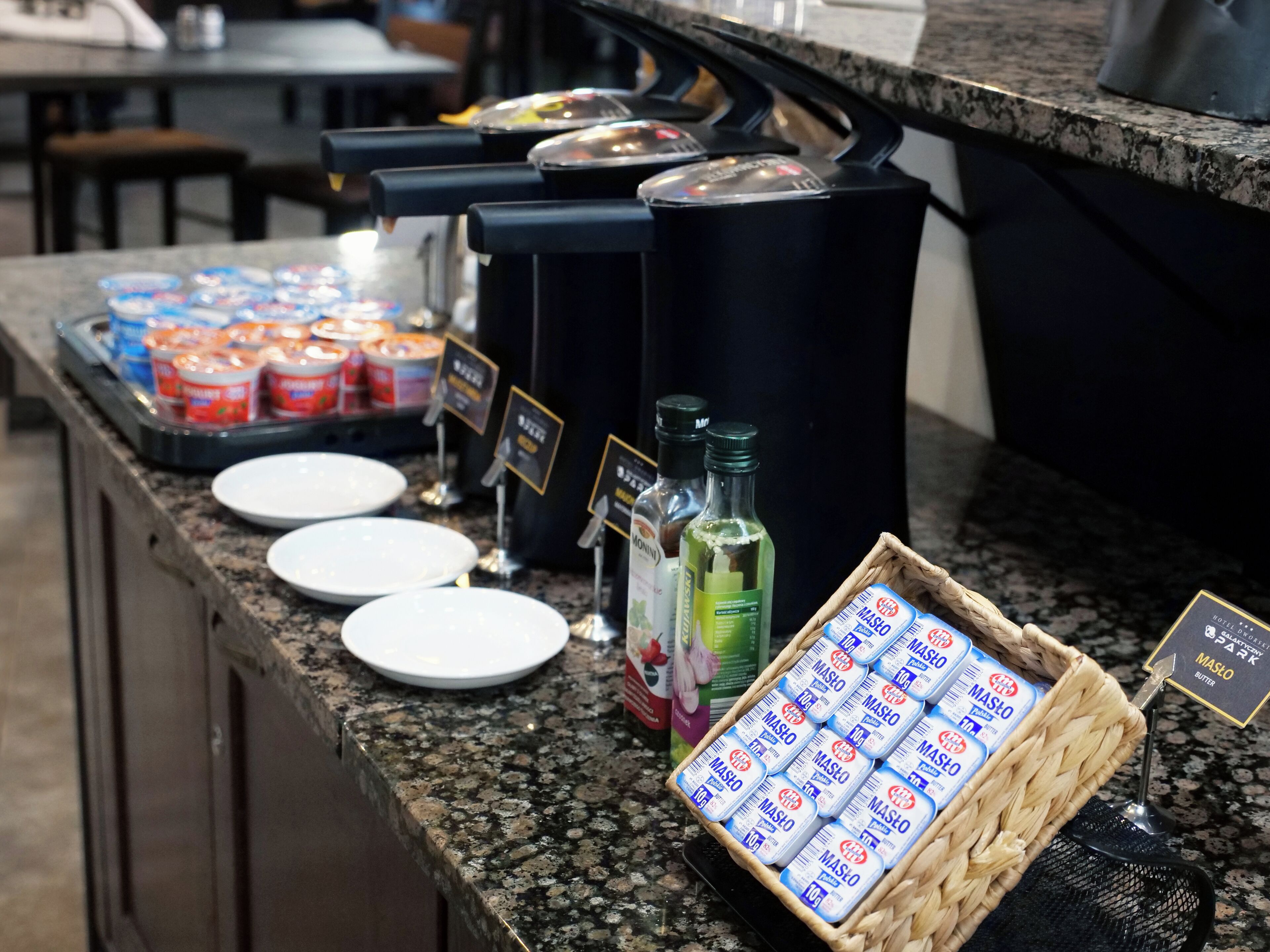 A buffet area with various food items, including jars of condiments, bottles of sauces, and a basket of Mashed potatoes.