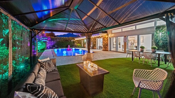 An outdoor patio with a glass enclosure, a pool, and a dining area with chairs and a table. - 4BR Intracoastal Retreat With Pool, Games & More! (West Palm Beach)