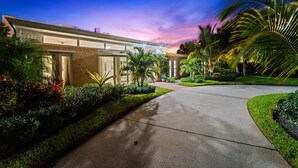 A modern building with a well-maintained garden and a paved driveway. - 4BR Intracoastal Retreat With Pool, Games & More! (West Palm Beach)
