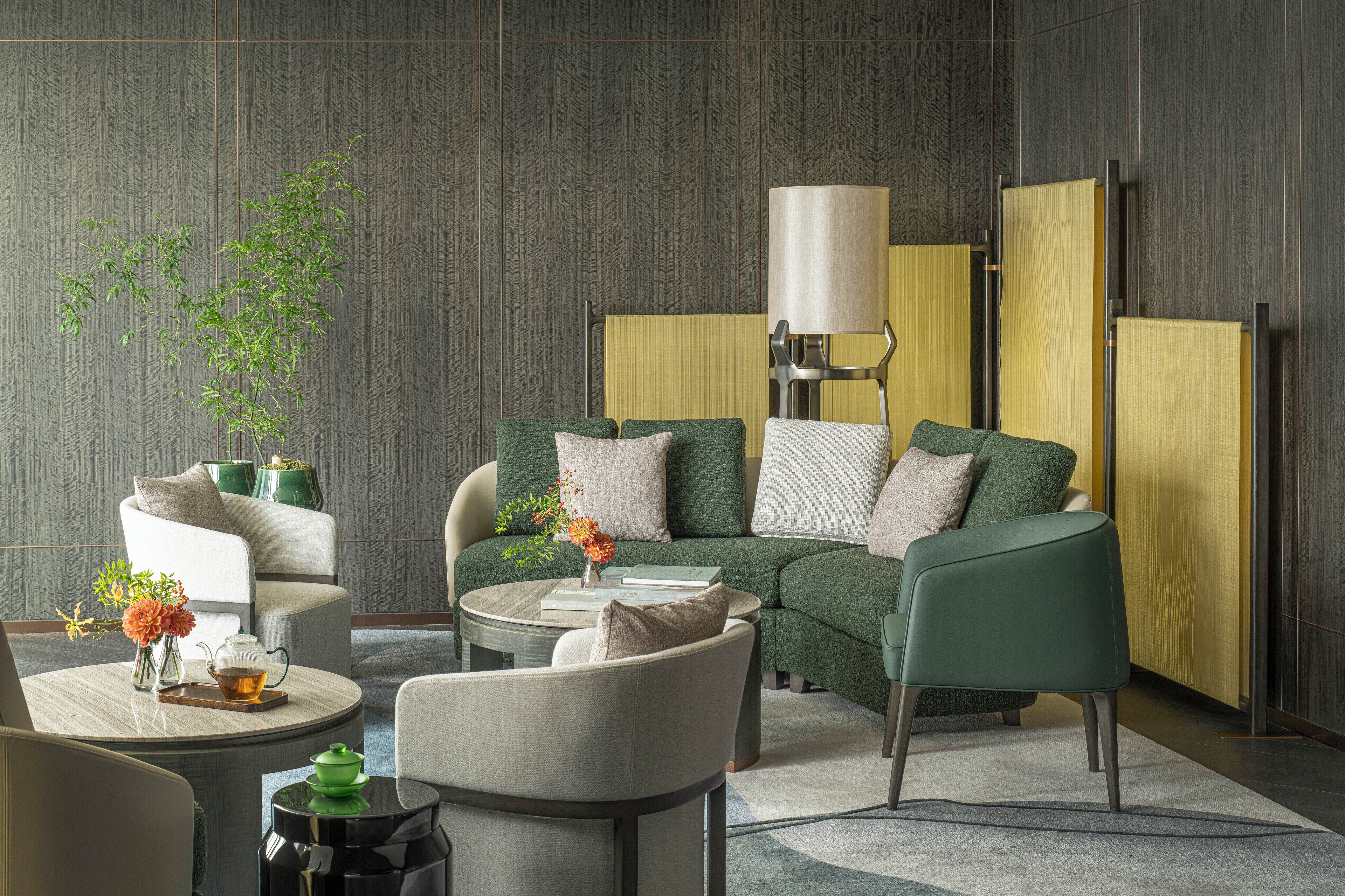 A modern living room with a sofa, armchairs, a coffee table, and a lamp.