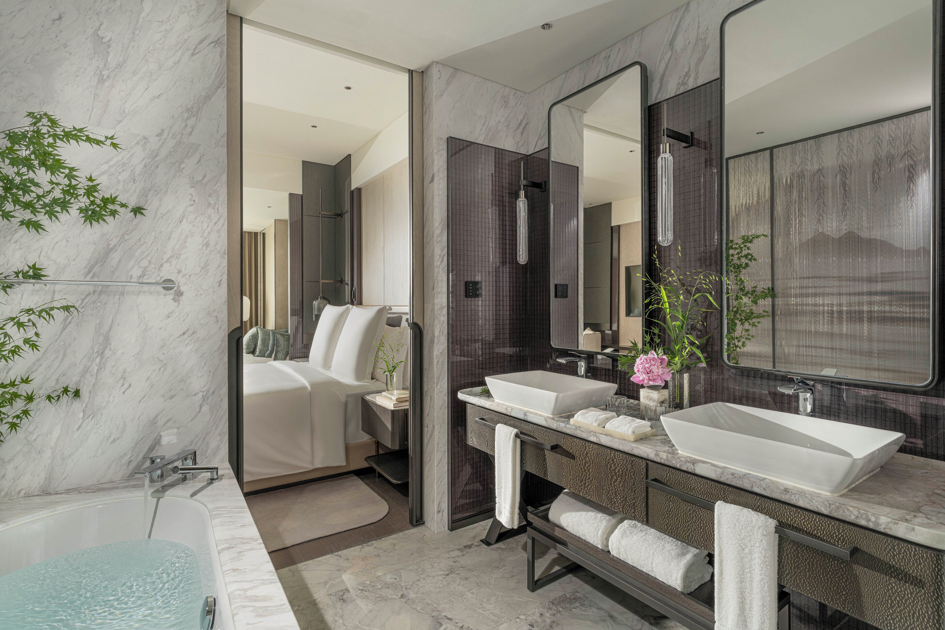 Un baño moderno con una bañera grande, dos lavamanos y una ducha a ras de suelo.