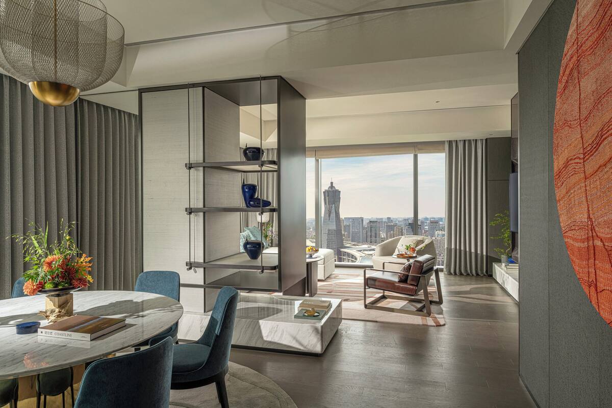 A modern living room with a city view, a dining area, and a large window.