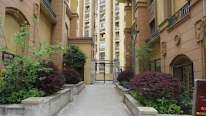 A narrow pathway flanked by buildings with balconies and a gate at the end. - Xiaowo Hostel (Chongqing)