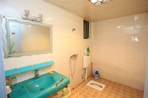 A bathroom with a sink, mirror, shower, and toilet. - Xiaowo Hostel (Chongqing)