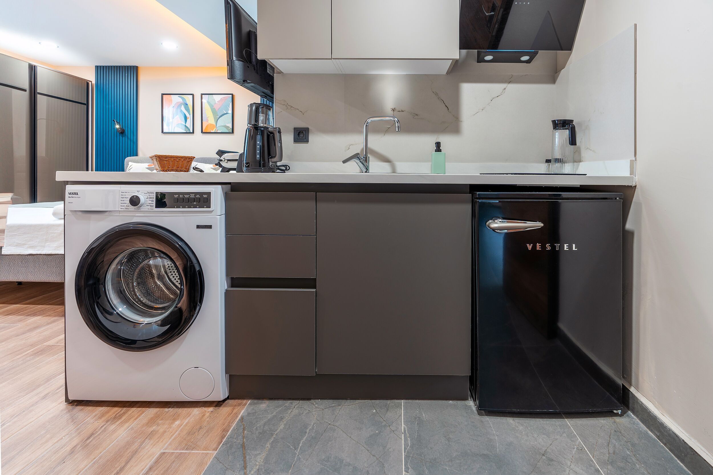 Een praktische keuken met een wasmachine, een vaatwasser en een spoelbak.