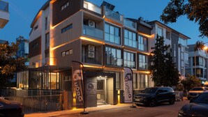 Een modern hotel met een gebogen gevel, grote ramen en een goed verlichte entree.