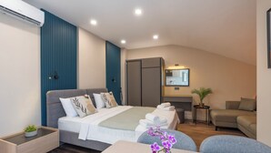 Een moderne hotelkamer met een bed, bureau, bank en eethoek.