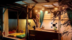 Een knus slaapkamer met een bed, kussens en een nachtkastje.