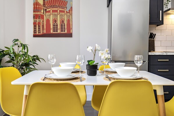 Enjoy a romantic dinner for two in this elegant dining area, complete with a beautifully set table and a charming kitchen view.