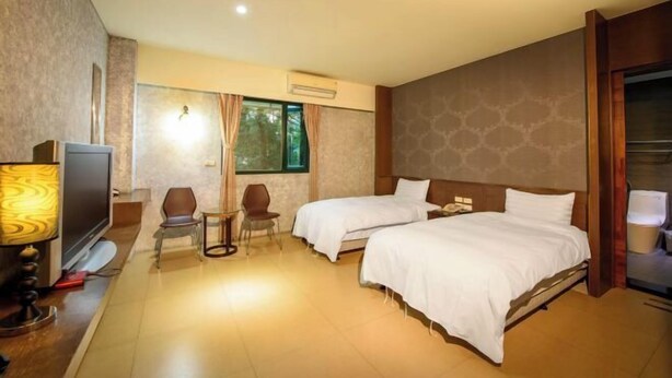 A hotel room with two beds, a TV, a desk, and a chair. - Xiang Ting (Nantou)