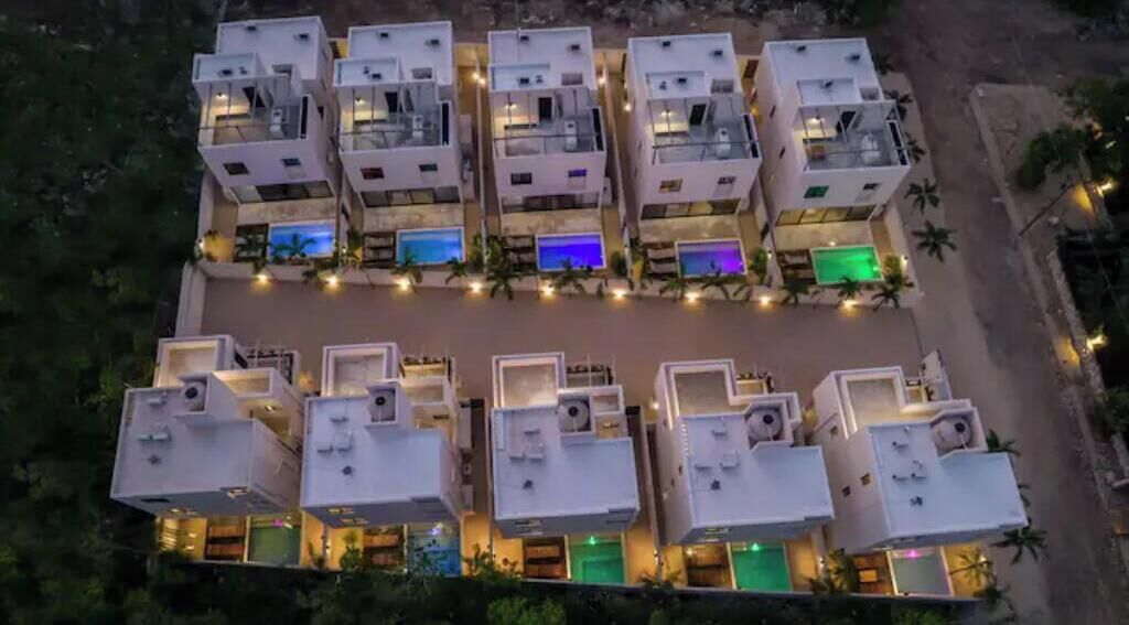 A modern hotel with multiple floors, each featuring balconies and outdoor pools.