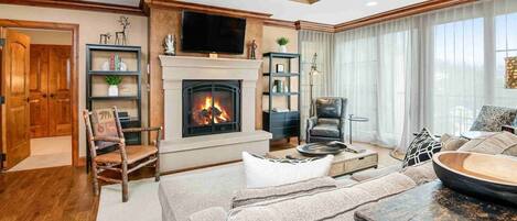 Un salon chaleureux avec une cheminée, des meubles en bois et un téléviseur.
