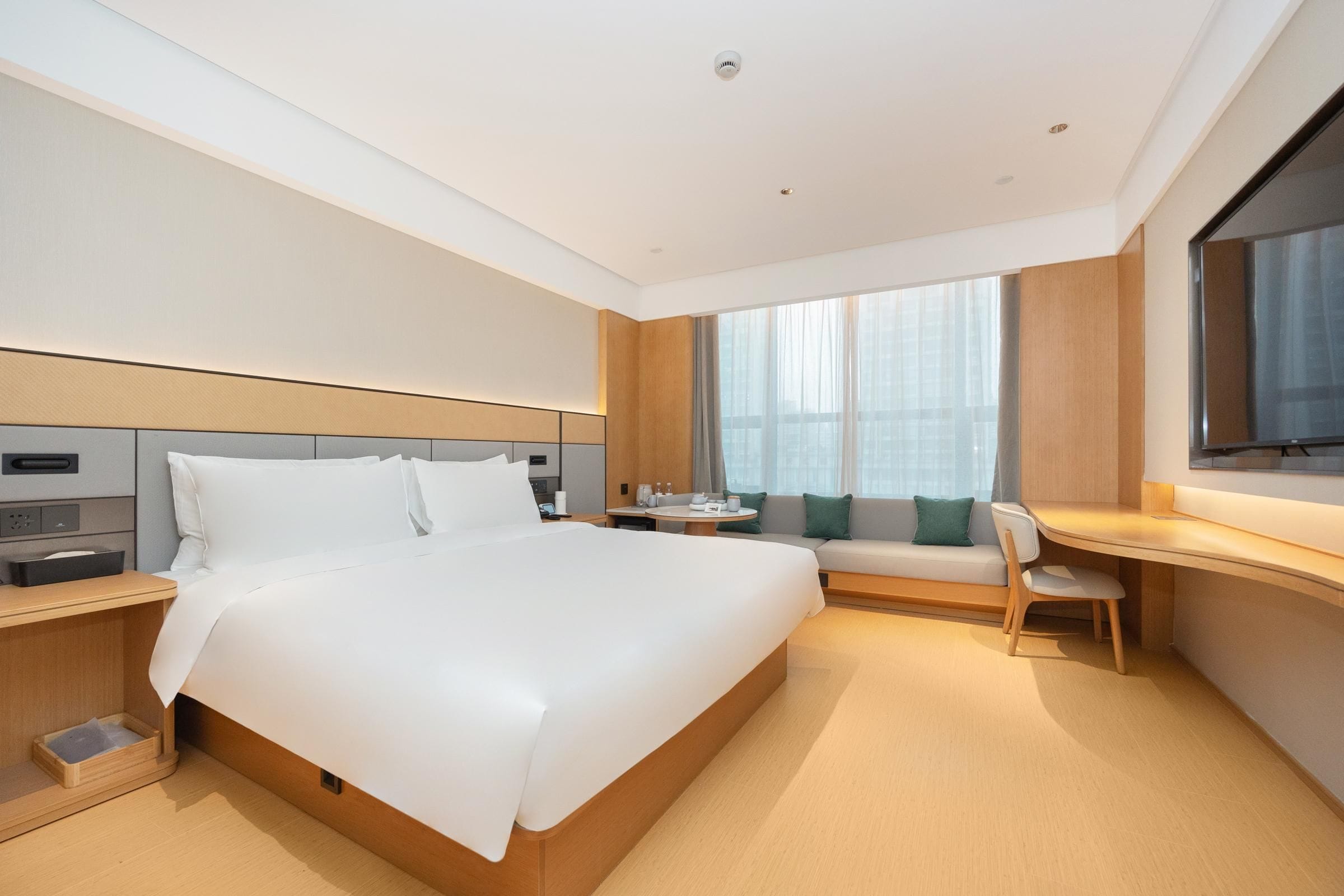 Une chambre d’hôtel moderne équipée d’un grand lit, d’un bureau, d’une chaise et d’un téléviseur.