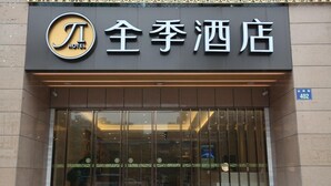 A hotel entrance with a large glass door, a sign with Chinese characters, and a blue address sign. - Ji Hotel Hangzhou Xiaoshan People Square (Hangzhou)