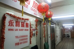 A hallway with a sign for Wing Lee Guest House, including contact numbers. - Wing Lee Guest House (Hong Kong)
