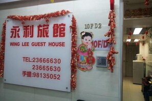Ein Schild mit Kontaktinformationen für das Wing Lee Guest House.