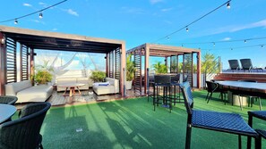 An outdoor patio area with a covered seating area, a dining table, and chairs. - Conforto em Tambaú próx ao mar (João Pessoa)