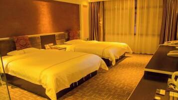 A hotel room with two beds, a desk, and a telephone.