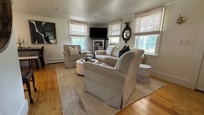 A living room with a sofa, armchairs, a coffee table, a TV, and a fireplace. - Ptown Paradise Farmhouse in the perfect, central location! (Provincetown)