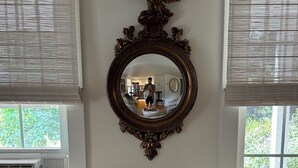 A living room with a large mirror, a sofa, and a window with blinds. - Ptown Paradise Farmhouse in the perfect, central location! (Provincetown)