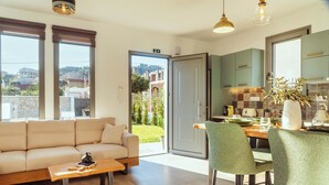 Un salon moderne comprenant un canapé, une table basse et un coin repas avec des chaises et une table.