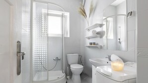 A modern bathroom with a glass-enclosed shower, a toilet, and a sink with a mirror above it. - Elite Apartments Wesola Economy (Gdansk)