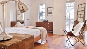 A bedroom with a bed, dresser, chair, and lamp. - Downtown Treetop Hideaway- SXSW, 6th St, UT Campus

 (Austin)