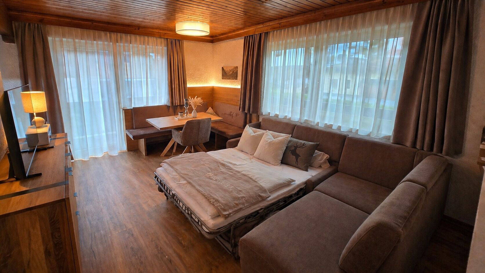 A cozy room with a bed, a desk, and a chair.