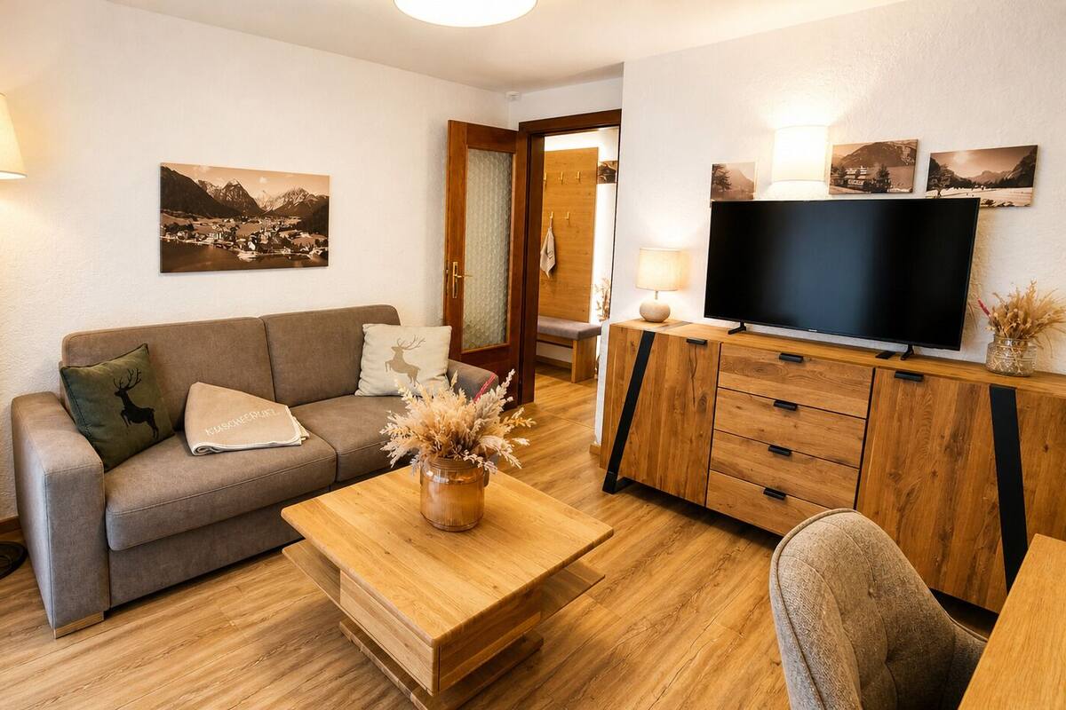 Un salon comprenant un canapé, une table basse, un téléviseur et des meubles en bois.