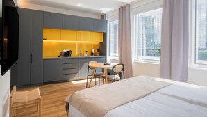 A modern hotel room with a bed, a desk, and a kitchenette. - Limehome Amsterdam Westerpark (Amsterdam)