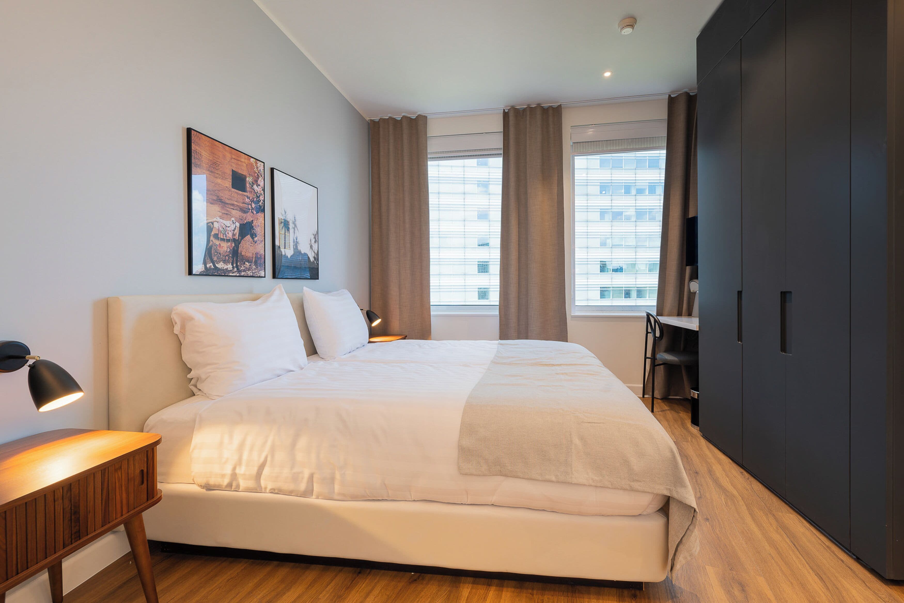Une chambre d’hôtel moderne avec un grand lit, un bureau et une armoire.