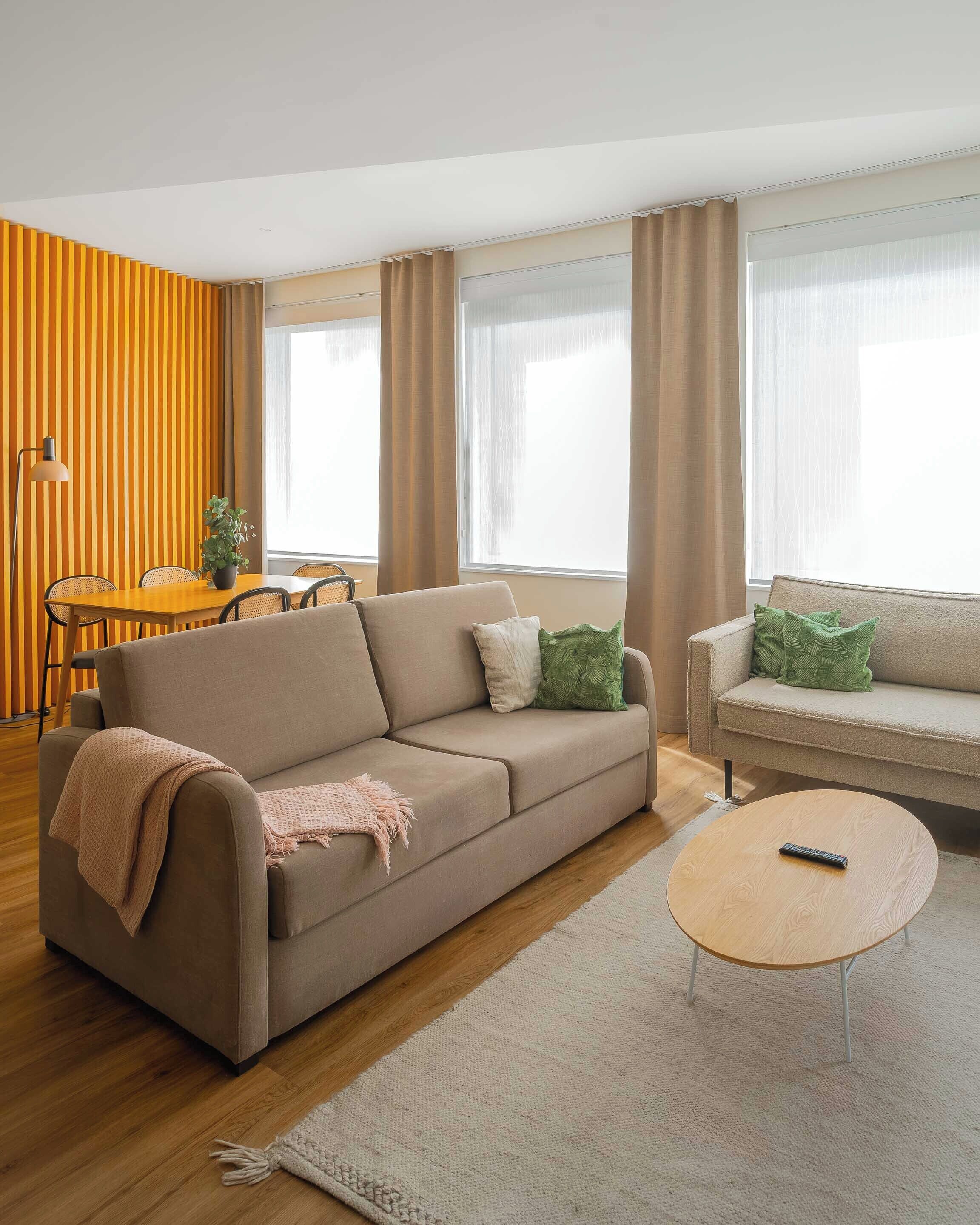 Ein Wohnzimmer mit einer Couch, einem Couchtisch und einem Essbereich mit Tisch und Stühlen.