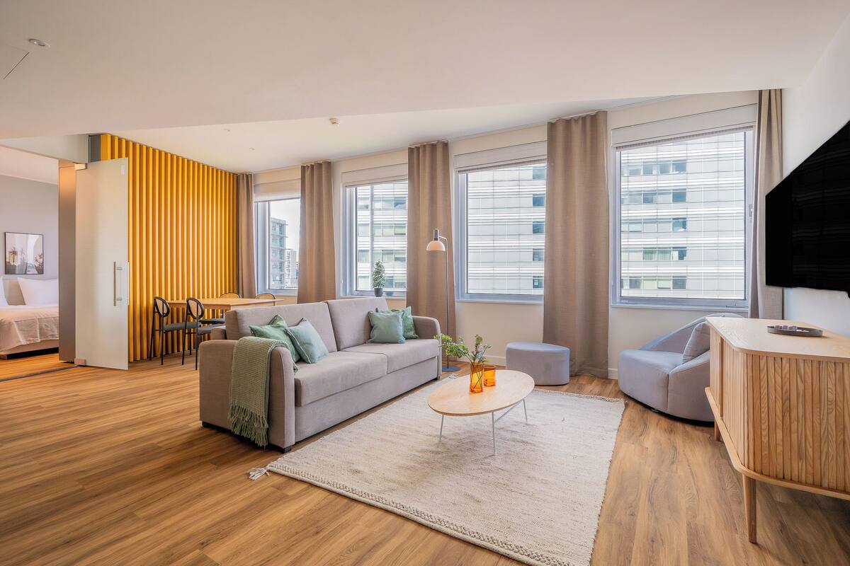 Una sala de estar moderna con un sofá, una mesa de centro y un mueble para televisión.