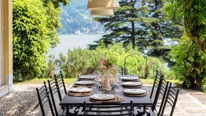 A table set for dining with a view of a lake and trees.