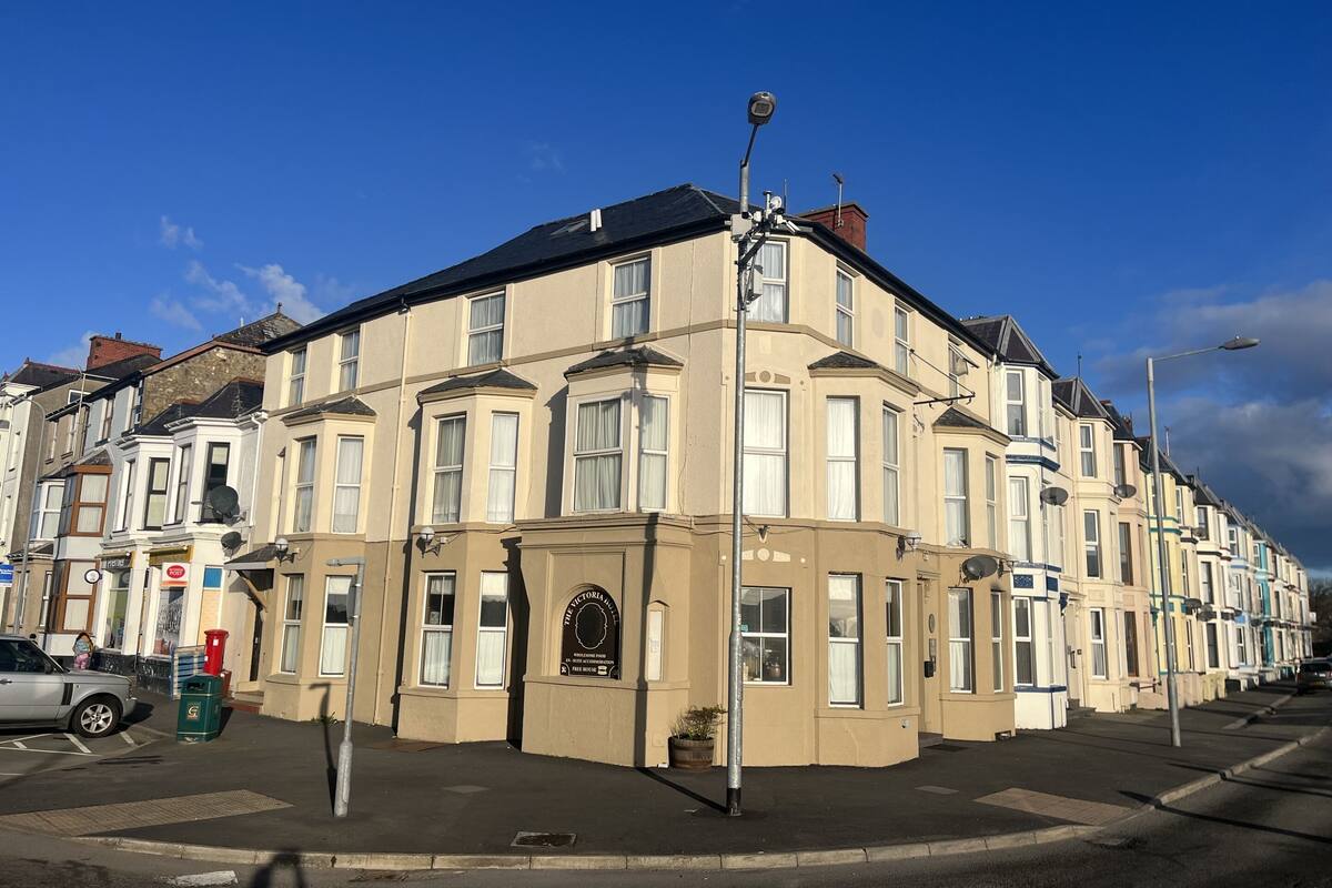 A row of terraced houses with a central building featuring a plaque.