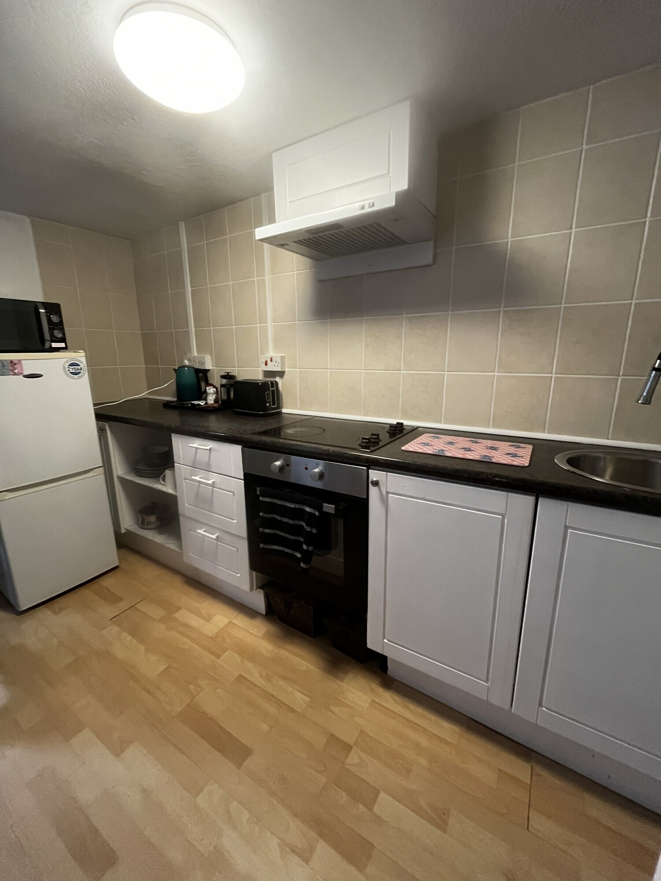 A compact kitchen with a microwave, toaster, and a dishwasher.