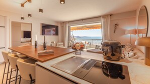 Eine moderne Küche mit einer großen Kochinsel, einer Kaffeemaschine und Meerblick.