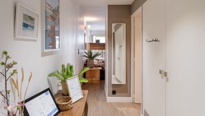 Un couloir avec un comptoir d’accueil, des œuvres d’art encadrées et un plancher en bois.