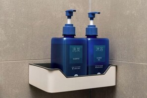 Bathroom features a shelf with pump dispensers and a textured tile finish.
