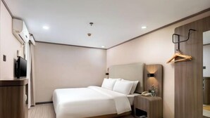 A modern hotel room with a large bed, a bedside table, a TV, and a wooden wardrobe. - Hilbert Hotel (Guangzhou Nansha Wanda Plaza Jinzhou Subway Station) (Guangzhou)