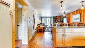 A kitchen with wooden cabinets, a large island, and pendant lighting. - Winter Park Condo w/ Resort Shuttle On-Site! (Winter Park)