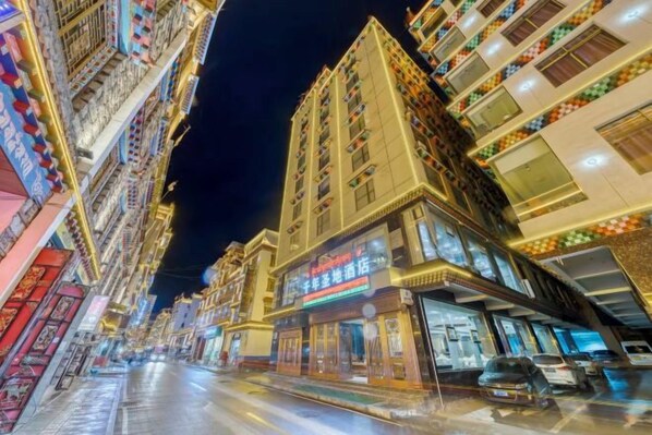 A street lined with multi-story buildings, some with visible signage and storefronts.