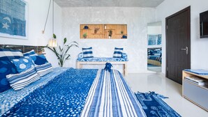 Una camera da letto moderna con un letto grande, una panca e uno scaffale in legno con piante.