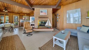 A cozy living room with a fireplace, wooden ceiling, and a dining area with a table and chairs. - Breathtaking Panoramic Views! Lake Huron & Lex! (Lexington)