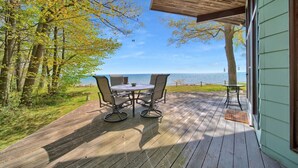 A wooden deck with a table and chairs overlooking a body of water. - Breathtaking Panoramic Views! Lake Huron & Lex! (Lexington)